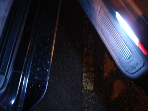1996 Ford Bronco - Interior view of a vehicle's door panel and floor, illuminated by interior lights.