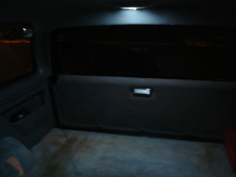 1996 Ford Bronco - Interior view of a dark vehicle with a ceiling light illuminating the rear cargo area.