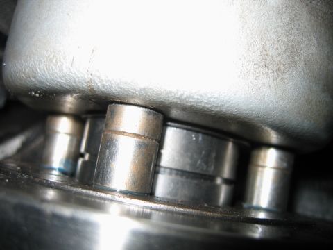 1992 Ford Bronco - Extreme macro shot of a mechanical assembly showing short cylindrical steel pins or studs, lightly surface-rusted, protruding between a pol…