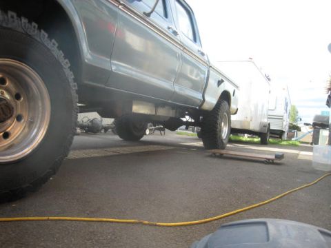 1976 Ford F-250 - A vintage Ford truck is parked next to a white trailer, with a yellow cord on the ground.