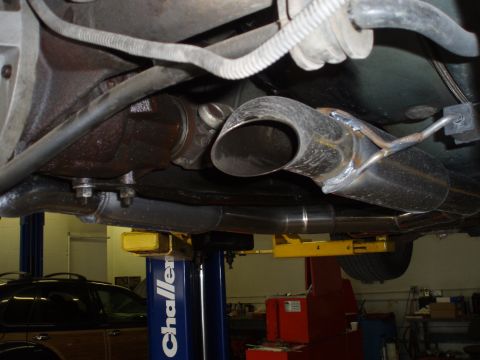 2002 Chevrolet Camaro - The underside of a vehicle is shown on a lift, focusing on the exhaust system and rear differential.