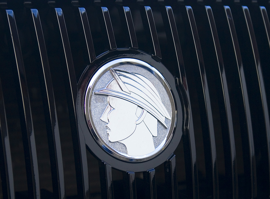 Chrome winged-head grille emblem on a black vertical-bar grille
