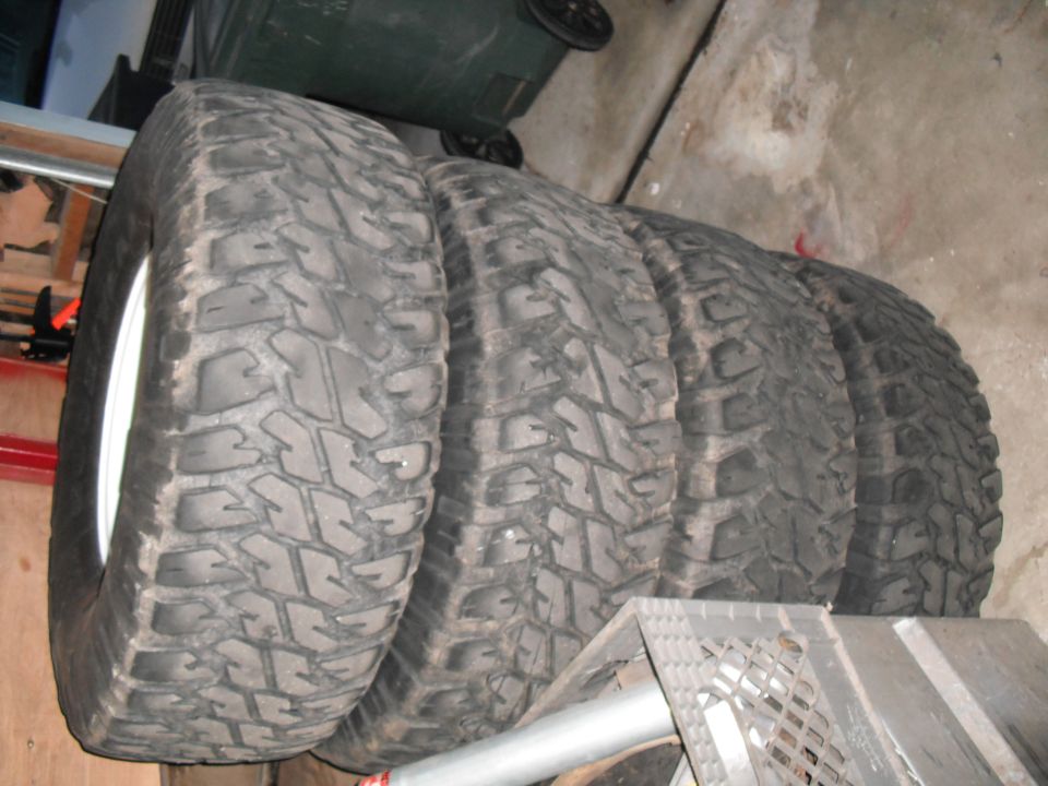 Four off-road tires with aggressive tread patterns