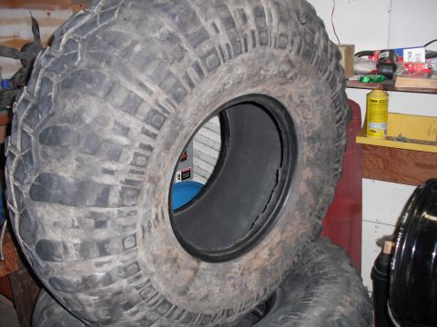 1991 Ford Bronco - A close-up view of a worn off-road tire, showing its deep tread and sidewall details.