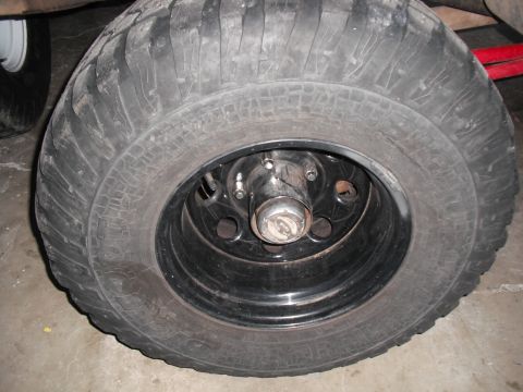 1991 Ford Bronco - Close-up of a vehicle's tire and wheel assembly, showing tread detail and a black rim.