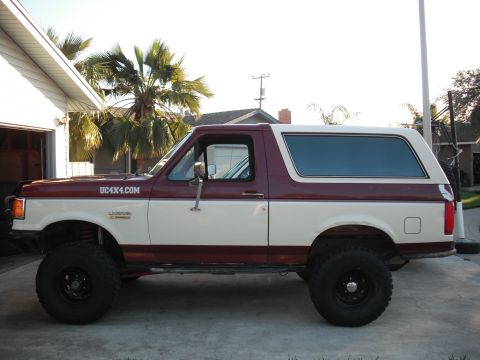 1991 Ford Bronco - This two-tone 1991 Ford Bronco features a maroon and white paint scheme and UC4X4.COM branding on the side.