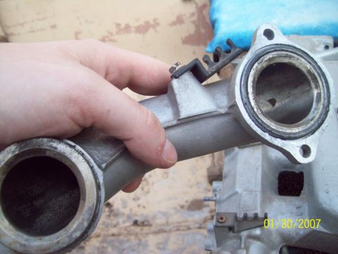 1995 Ford Probe - A close-up view of an automotive intake manifold part being held by a hand.