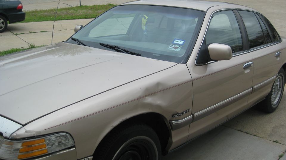 1992 Ford Crown Victoria, tan, dent on front fender. Texas inspection sticker on windshield
