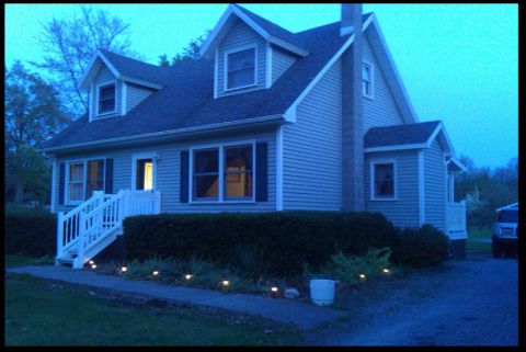 1966 Ford Five Hundred - Exterior view of a house at dusk with illuminated walkway lights.