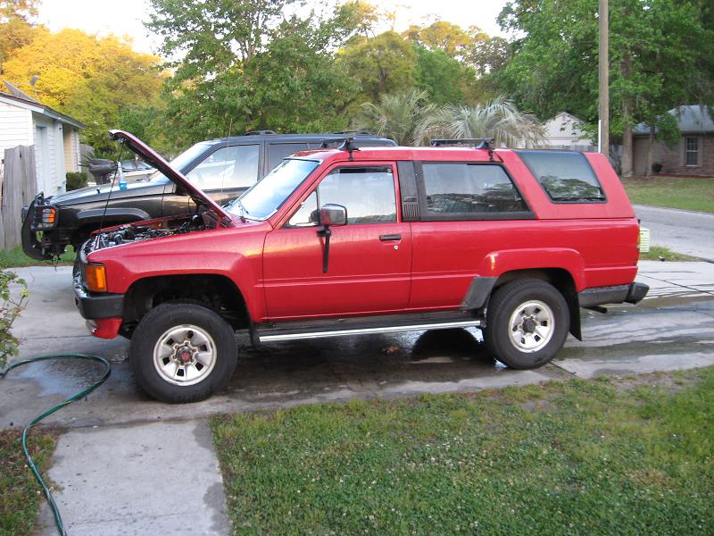 Red 4Runner SUV parked in driveway with hood open, side view