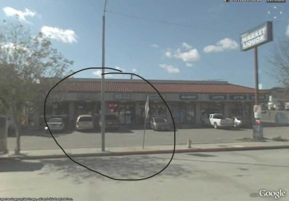 Street view of a market and liquor store with cars parked out front