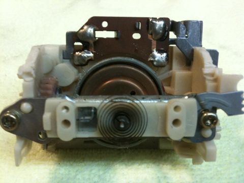 Suzuki Samurai - Close-up of a mechanical component, possibly an actuator or switch, with visible wiring and spring mechanism.