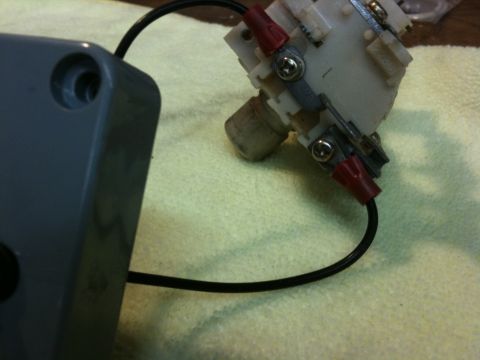 Suzuki Samurai - Extreme close-up of a small white plastic electrical switch or relay assembly with red insulated spade terminals and Phillips screws, wired…