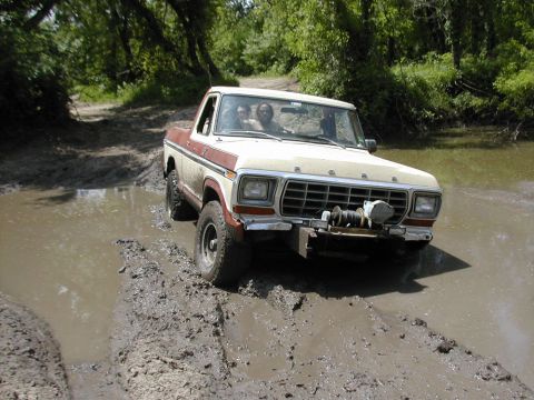 1979 Ford Bronco - This truck is navigating a muddy trail with water obstacles.