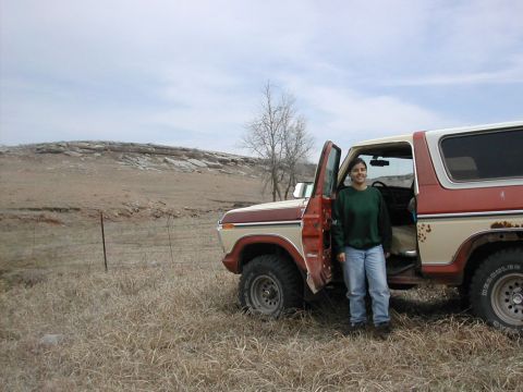 1979 Ford Bronco - Woman poses with a 1978 Ford Bronco in a dry, outdoor setting with a rocky hill in the distance.