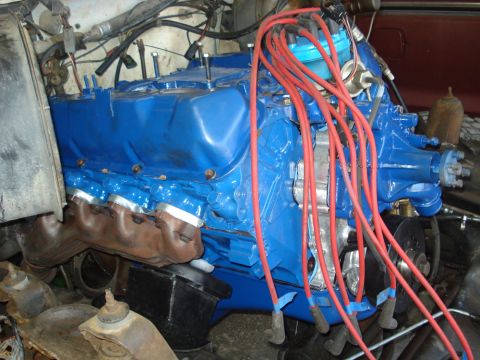 1979 Ford Bronco - The engine bay shows a blue V8 engine with prominent red spark plug wires and exhaust manifolds.