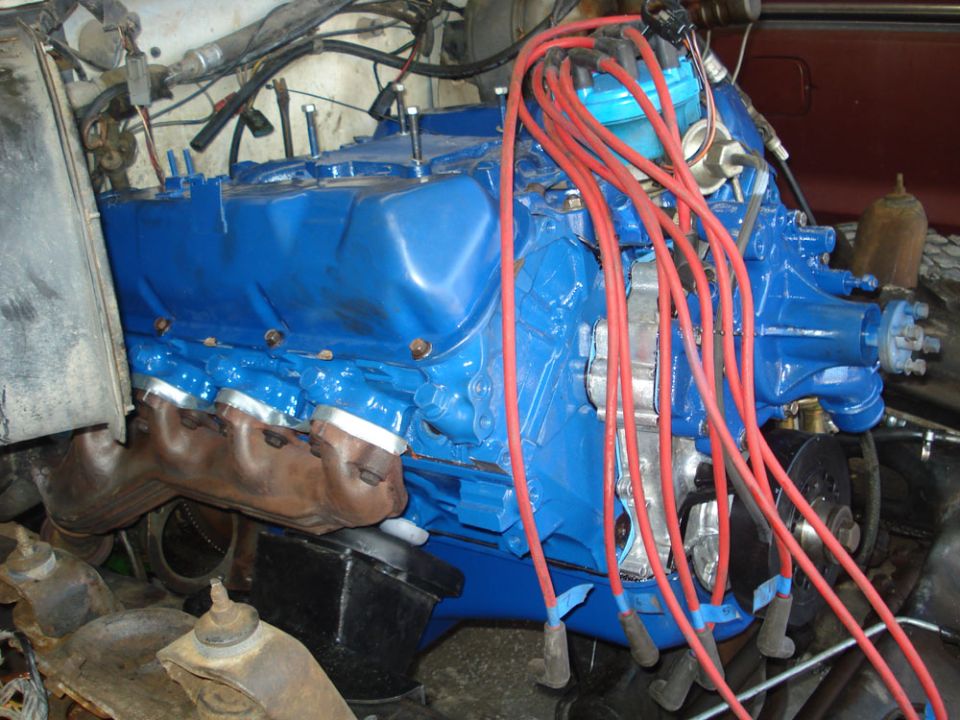 Close-up of a blue V8 engine with red spark plug wires
