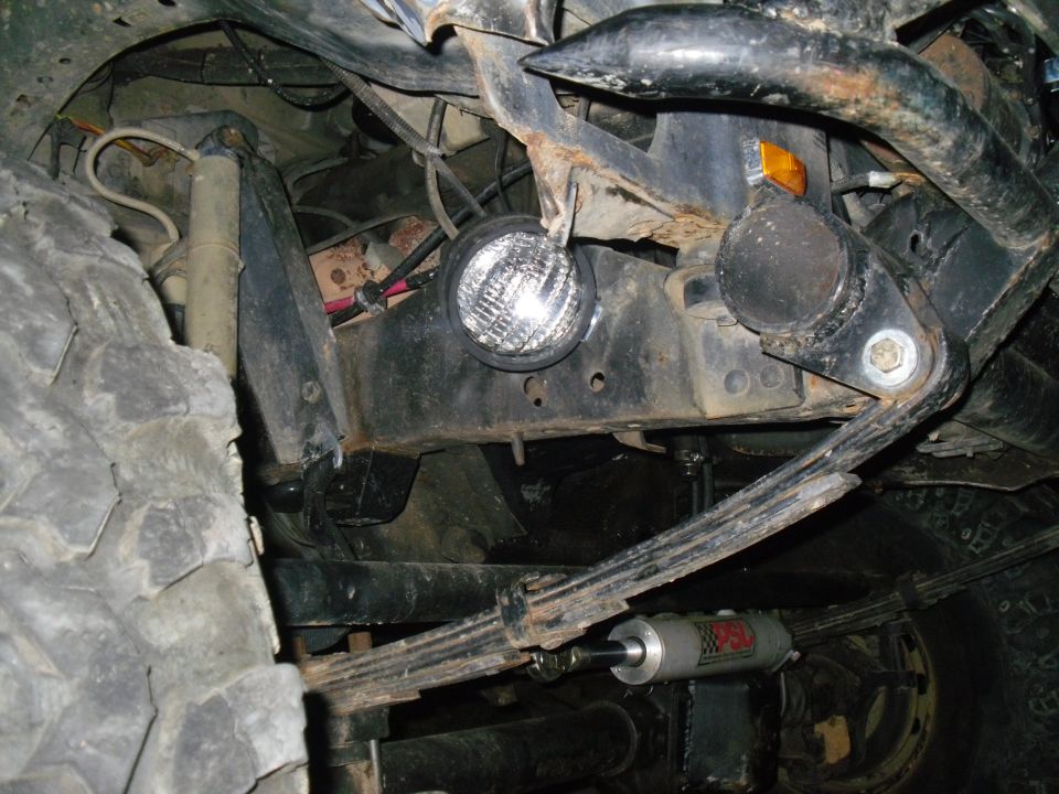 Undercarriage view of a vehicle's suspension with a large tire and shock absorber