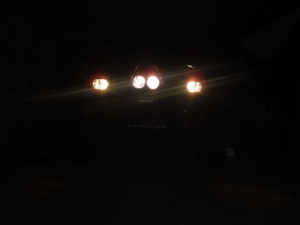 1984 Ford Bronco II front view with headlights on in darkness