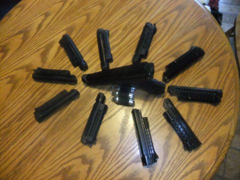 1978 Chevrolet C/K Pickup - Several paintball gun parts are laid out on a wooden table surface.