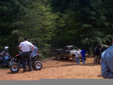 1983 Ford Bronco - A group of people stand around ATVs and a pickup truck in a wooded area.