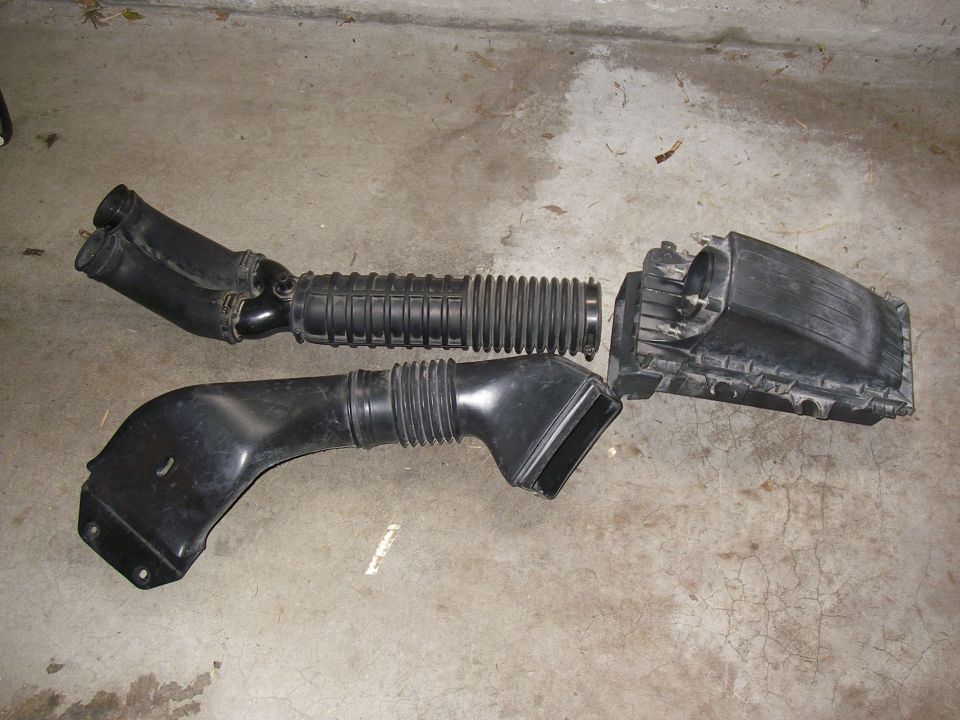 Air intake ductwork and air box assembly laid out on a concrete garage floor