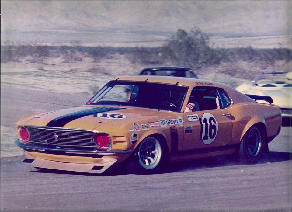 Orange and black number 16 Boss 302 Mustang race car on track