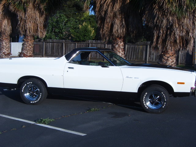 Side view of a 1973 Ford Ranchero with black trim and hood