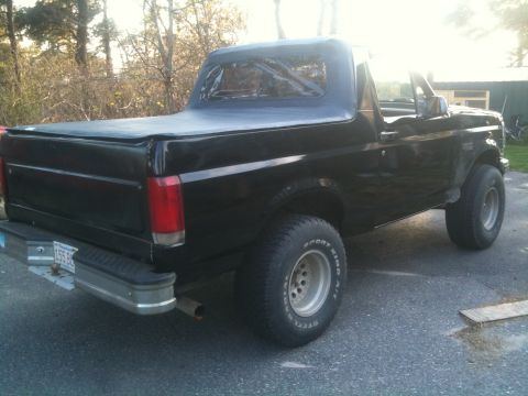 1993 Ford Bronco - This 1993 Ford Bronco is seen from the rear, a black soft top and a chrome bumper.