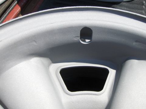 1980 Chevrolet Camaro - Close-up of a gray car wheel rim, showing a GM logo and lug nut holes.