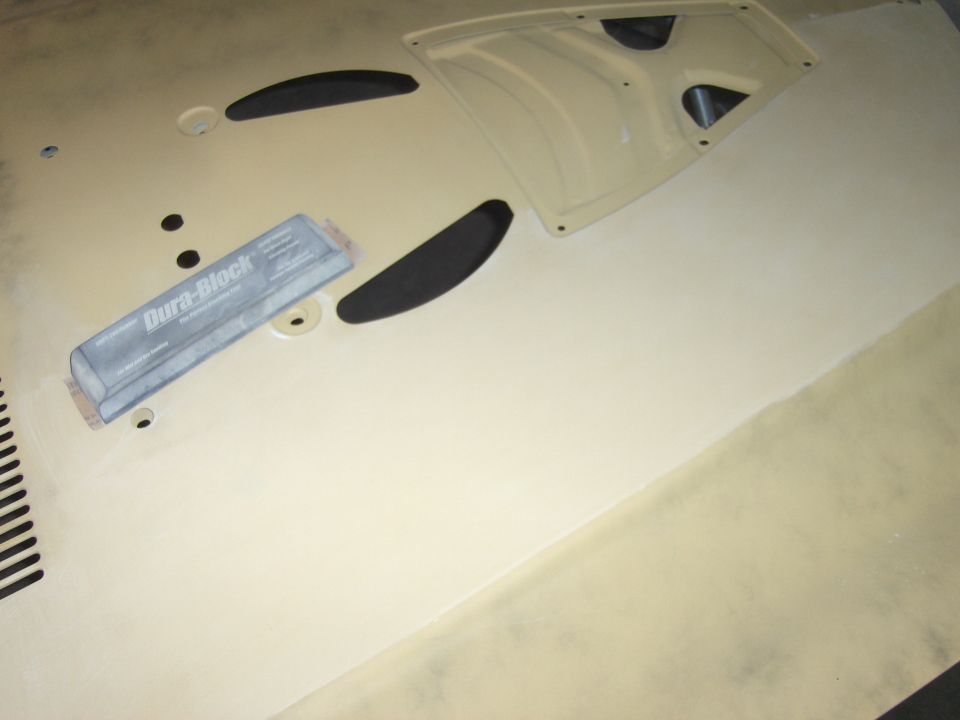 Beige car hood with black trim pieces and a Dura-Block sanding block