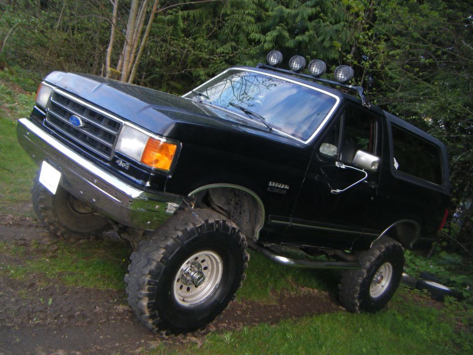 1990 Ford Bronco, black, lifted with off-road tires and roof lights