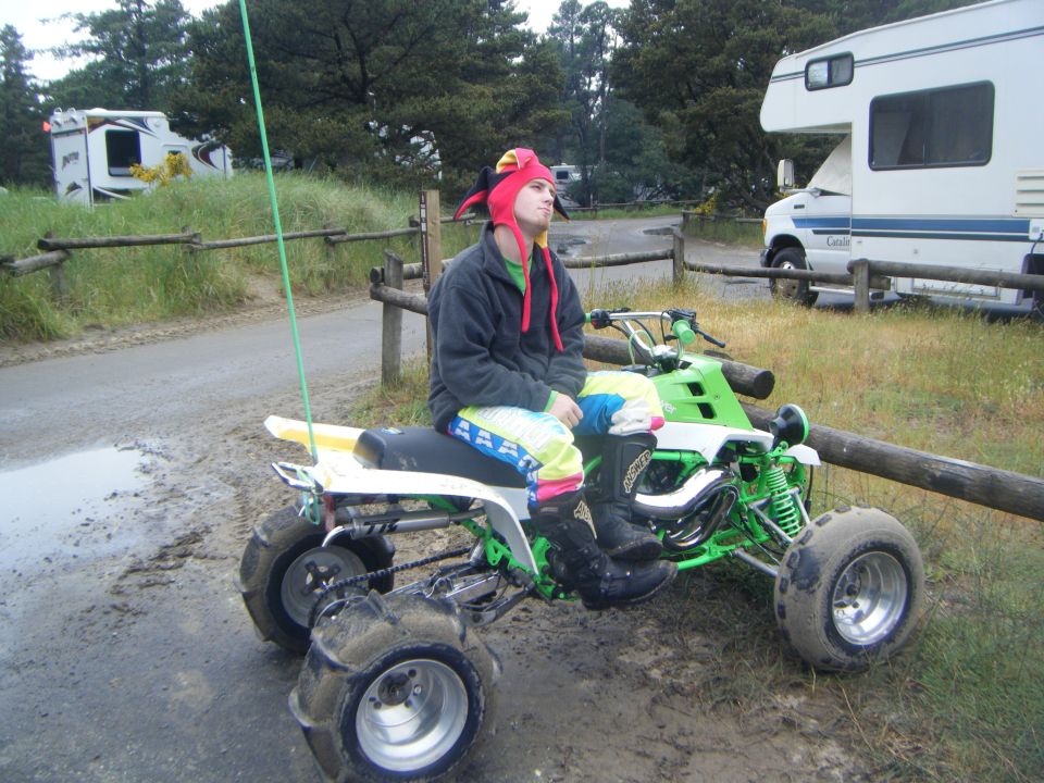 Green and white ATV with sand tires, rider in jester hat