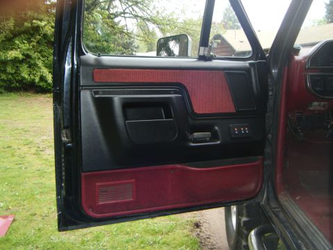 1990 Ford Bronco — Black and red interior door panel with power window controls