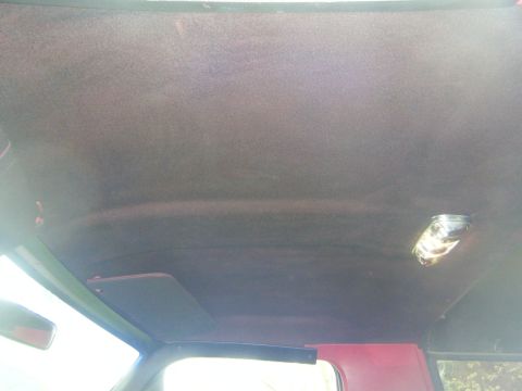 1990 Ford Bronco — Interior shot of a vehicle's headliner with a dome light and a sun visor visible
