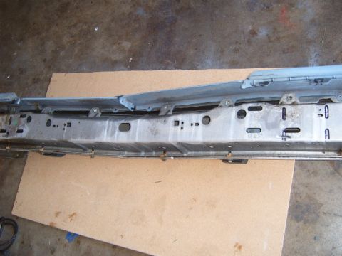 1973 Ford Ranchero - Close-up view of a car's bumper support structure, showing mounting hardware and some painted markings.
