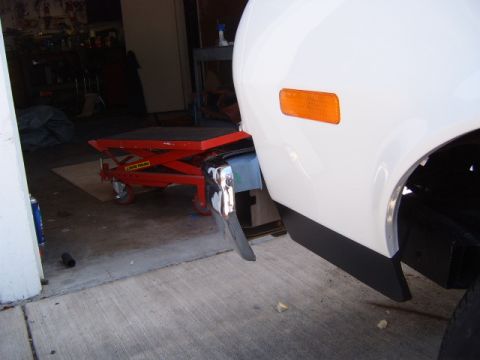 1973 Ford Ranchero - Close-up of the rear quarter panel of a white 1973 Ford Ranchero, showing the orange marker light and black lower trim.