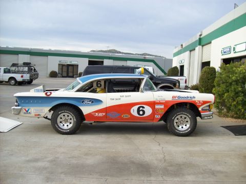 1990 Ford Bronco - A modified 1958 Ford Fairlane race car with off-road tires is parked outside a building.