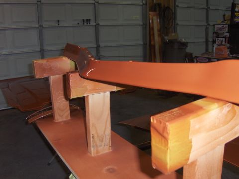 1980 Chevrolet Camaro - A car part is mounted on wooden supports, ready for painting in a garage setting.