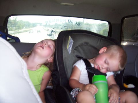1994 Ford Bronco - Children sleeping in car seats during a road trip, with the highway visible through the rear window.