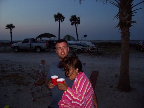 1994 Ford Bronco - People enjoy drinks at a beach campsite with a pickup truck and boat in the background.