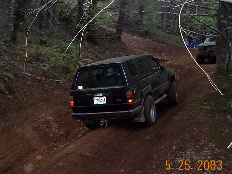 Black Toyota 4Runner climbing a forest dirt trail, rear view, dated 5.25.2003