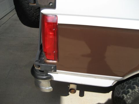 Rear corner of a white and brown 1993 Ford Bronco with spare tire