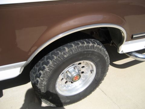 1993 Ford Bronco front wheel and brown fender with chrome trim