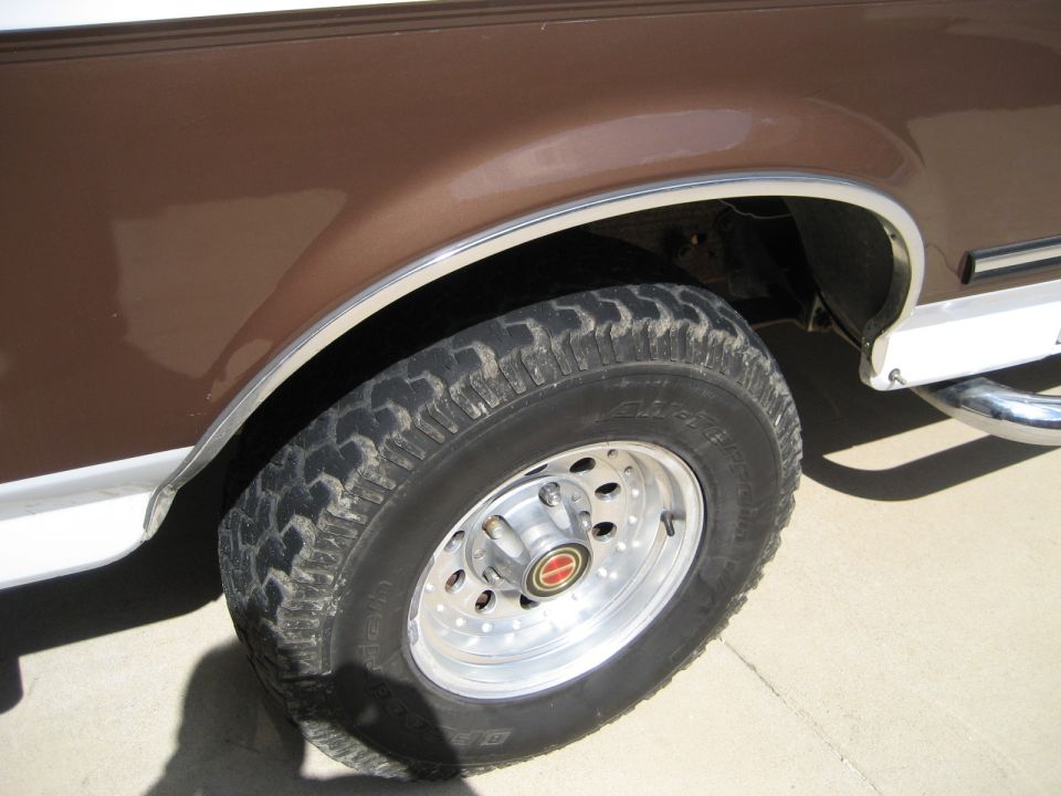 1993 Ford Bronco front wheel and brown fender with chrome trim