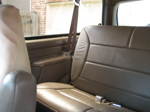 1993 Ford Bronco — Back seat and interior door panel of a vehicle. A watermark says "SUPERMOTORS www.supermotors.net"