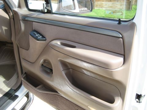 1993 Ford Bronco — Tan interior door panel with power window controls and storage pocket