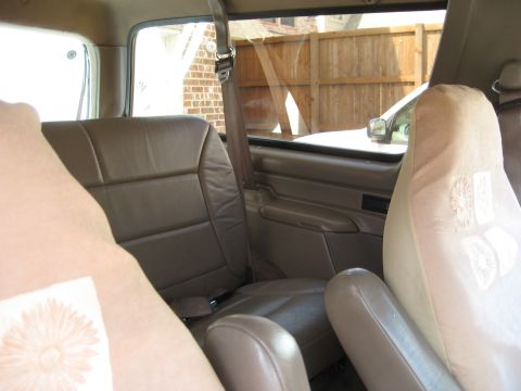 1993 Ford Bronco interior showing tan leather seats and seat covers