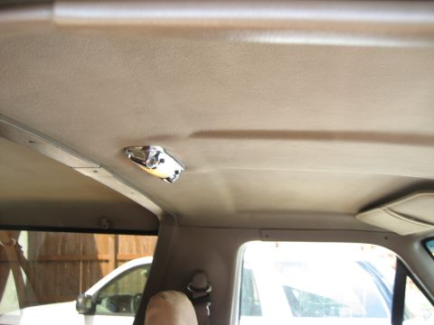 1993 Ford Bronco — Interior shot of a vehicle's headliner with a dome light. Another vehicle is visible through the window