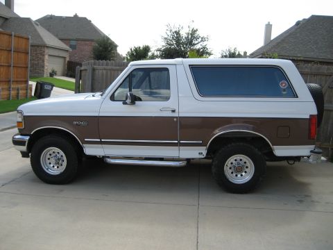 1993 Ford Bronco - This two-tone 1993 Ford Bronco is shown from the side, a brown stripe along its lower body.